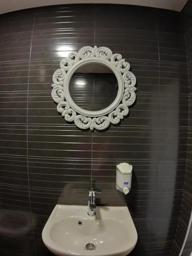 baño con lavabo y espejo en la pared en Apartments In Heart, en Sarajevo
