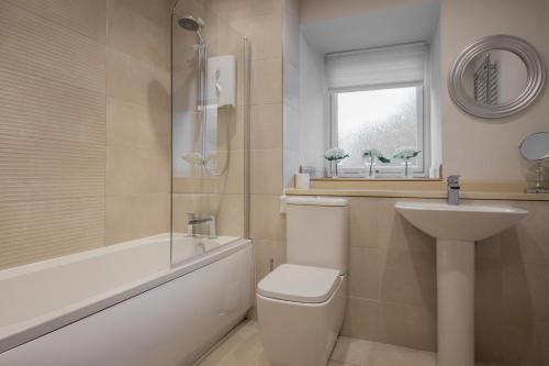 a bathroom with a toilet and a sink and a tub at The Armoury in Glenfinnan