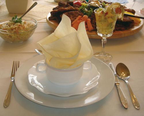 einen Tisch mit einer Tasse und einem Teller Essen in der Unterkunft Märkisches Landhaus & Pension Bartsch in Berkenbrück