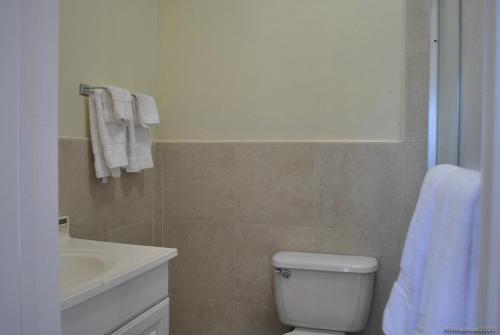 a bathroom with a white toilet and a sink at Tropical Hideaway in Nassau