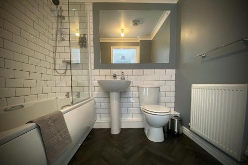 a bathroom with a sink and a toilet and a mirror at Appleby Darlington Two in Darlington