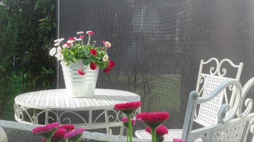un jarrón de flores sentado en una mesa en un patio en bed & breakfast filderstadt by heller en Filderstadt