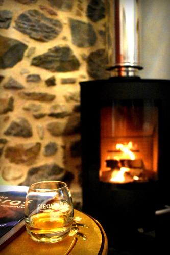 a glass of whisky sitting on a table next to a fireplace at The Auld Reekie in Barbaraville