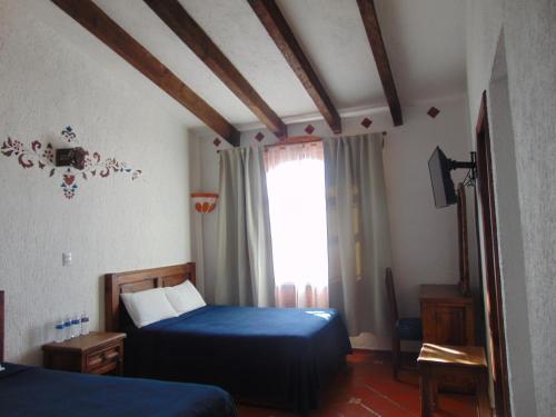 1 dormitorio con 2 camas y ventana en La casa de la abuela, en San Cristóbal de Las Casas