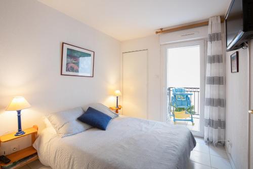 une chambre avec un lit et une fenêtre avec une chaise dans l'établissement Palazzio Vieux Port by Welcome to Cannes, à Cannes