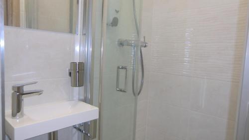 ein Bad mit einer Dusche und einem Waschbecken in der Unterkunft HU in Prag