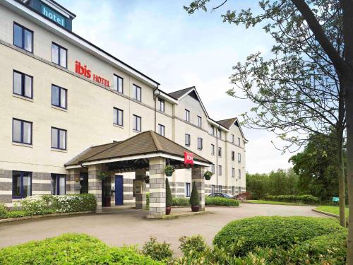 a large white hotel with a gazebo in front of it at ibis Rugby East in Crick