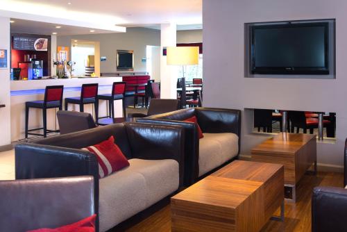 a living room with couches and a bar with a tv at Holiday Inn Express Stoke-On-Trent by IHG in Stoke on Trent