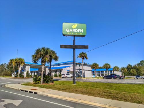 a sign for a car dealership in front of a building at Garden Inn & Suites in Pensacola