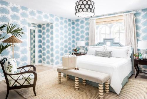 a blue bedroom with a bed and a chair at The Colony Hotel in Palm Beach