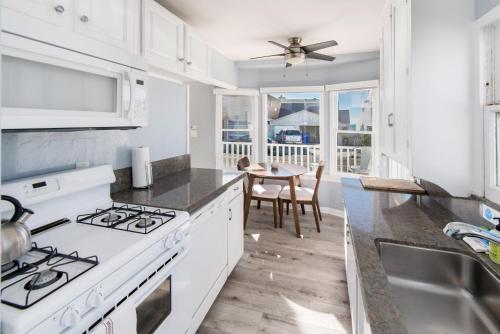 a kitchen with white appliances and a dining table at Pacific Bungalow in Oceanside with Backyard & Tiny House in Oceanside