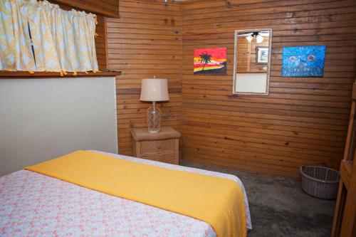 a bedroom with a bed in a wooden wall at Blue Island Divers Casa Descanso in Sandy Bay