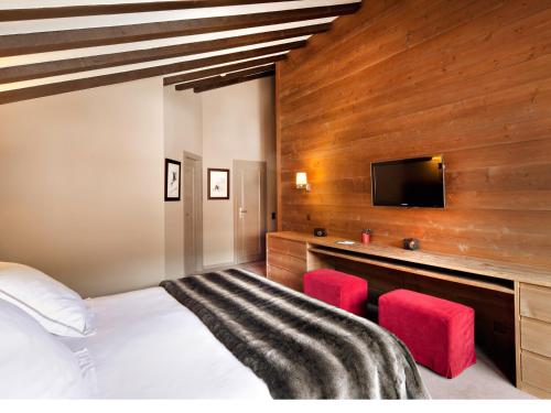 a bedroom with a bed and a flat screen tv at Hôtel Vanessa in Verbier