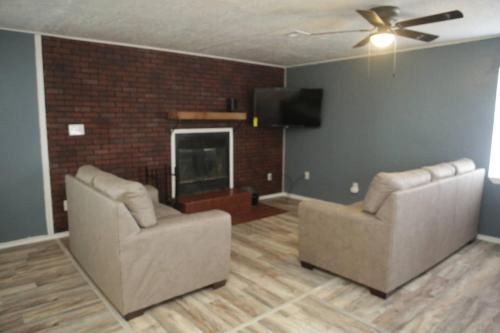 a living room with two chairs and a flat screen tv at 1 bedroom with a fireplace close to base in Lawton