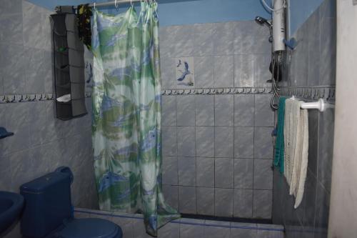 a shower with a shower curtain in a bathroom at Passion Hostel - Lima Airport in Lima
