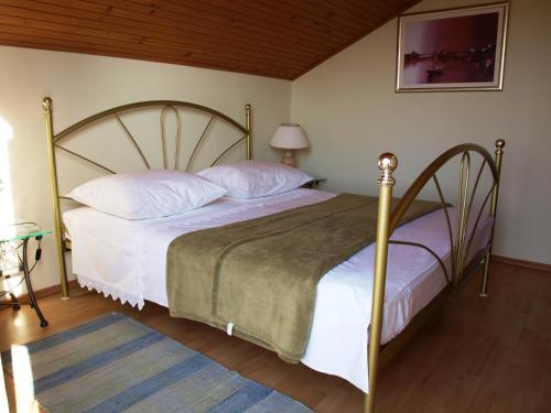 um quarto com uma cama grande com lençóis brancos e almofadas em Apartment Zvonar em Okrug Donji