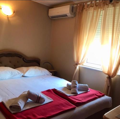 1 dormitorio con 1 cama con toallas y ventana en Vrdnik Apartmani Bahus, en Vrdnik