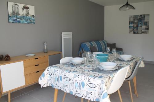 une table à manger avec des chaises et un tissu de table dans l'établissement MAGNIFIQUES APPTS à côté DE LA PLAGE, à Andernos-les-Bains