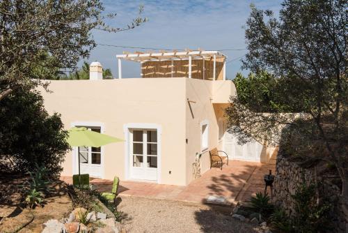 a white house with a building in the background at Lovely Rustic Casa Catita with amazing roof terrace views in Tavira