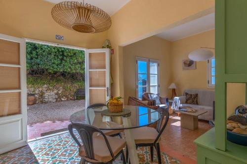 a living room with a glass table and chairs at Lovely Rustic Casa Catita with amazing roof terrace views in Tavira