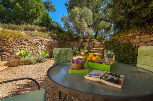 a table and chairs with a book and fruit on it at Lovely Rustic Casa Catita with amazing roof terrace views in Tavira