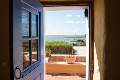 an open door with a view of the ocean at Luazinha - Lovingly renovated Fisherman's cottage in Tavira