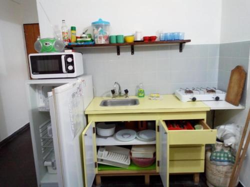 a small kitchen with a sink and a microwave at Ayre del Tuyu in Mar del Tuyú