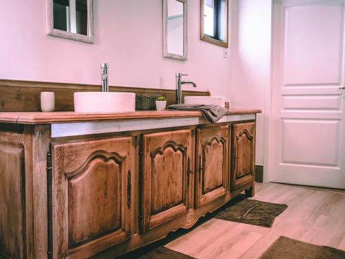 a bathroom with a wooden vanity with a sink at La Belle Landaise 1809 studio 4 couchages in Peyrehorade