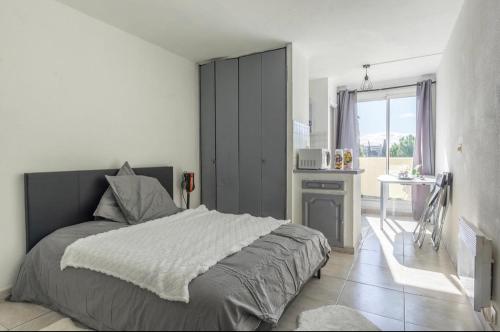 une chambre avec un lit et une table dedans dans l'établissement Grand appartement doté d'une terasse avec magnifique vue, à Montpellier