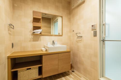 een badkamer met een wastafel en een douche bij GRAND BASE Mojiko Ekimae in Kitakyushu