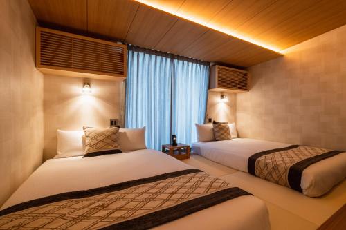 מיטה או מיטות בחדר ב-GRAND BASE Mojiko Ekimae