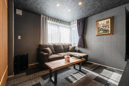 a living room with a couch and a table at GRAND BASE Mojiko Ekimae in Kitakyushu