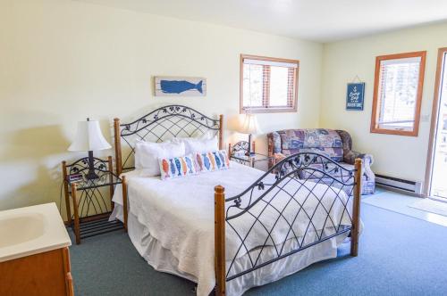 a bedroom with a bed and a chair at Sea Treasures Inn in Seward