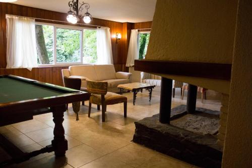 a living room with a pool table and a fireplace at Solares Cumbrecita Hotel & Apart in La Cumbrecita