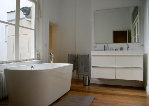 une salle de bain blanche avec une baignoire et un lavabo dans l'établissement Mokum Suites, à Amsterdam