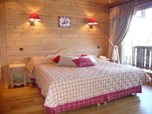 - une chambre avec un lit et un mur en bois dans l'établissement Aux Ducs de Savoie, à Combloux