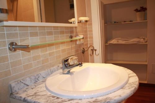 y baño con lavabo blanco y espejo. en Suite Lungara, en Roma