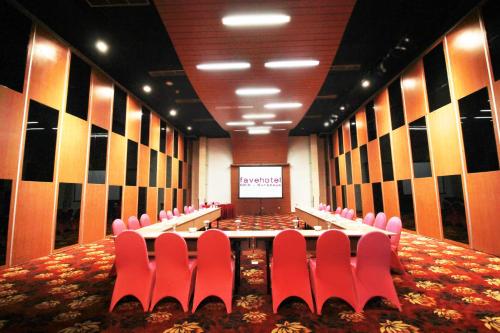 a conference room with red chairs and a screen at favehotel MEX Tunjungan Surabaya in Surabaya