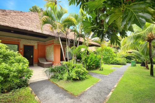 a house with a pathway leading to a garden at Legian Beach Hotel in Legian