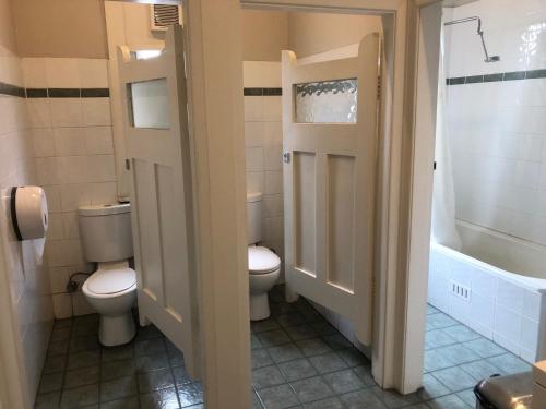 La salle de bains est pourvue de 2 toilettes, d'un lavabo et d'une baignoire. dans l'établissement Wentworth Hotel, à Sydney
