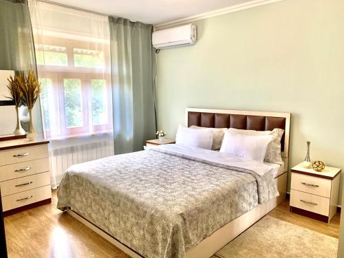 a bedroom with a large bed and a window at Samarkand Apartment in Samarkand