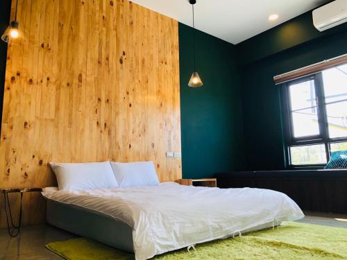 a bedroom with a bed with a wooden wall at Twenty Eight B&B in Xiaoliuqiu