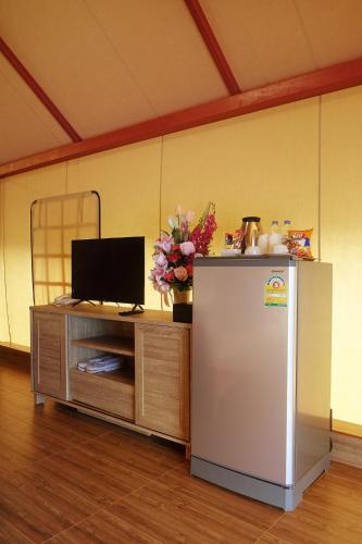 a room with a refrigerator and a table with flowers at Tayama Farm Khaoyai in Nakhon Ratchasima