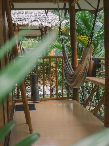 a hammock on a porch with a deck at Orion Healing Centre in Srithanu