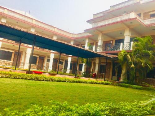 a large building with a lawn in front of it at sakya guest house in Lumbini