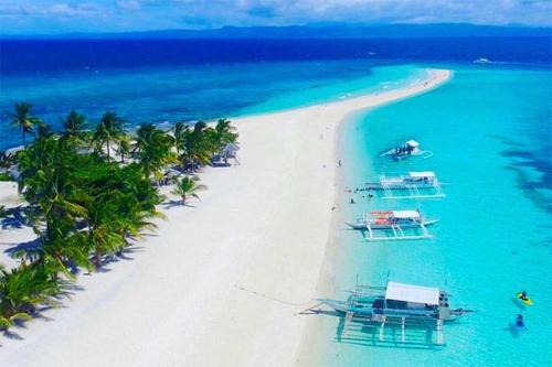 an aerial view of a beach with boats in the water at Leizel's Bed & Breakfast in Palompon