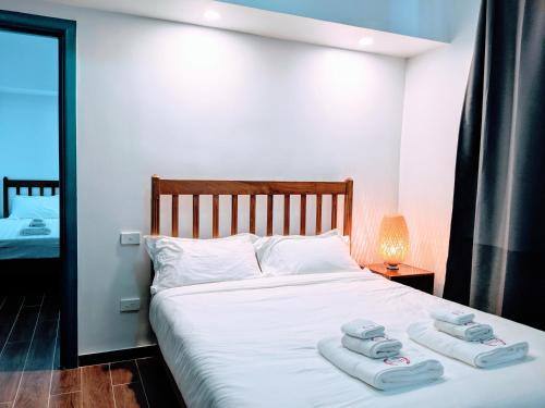 a bedroom with a white bed with towels on it at Pacific Crown Hotel in Honiara