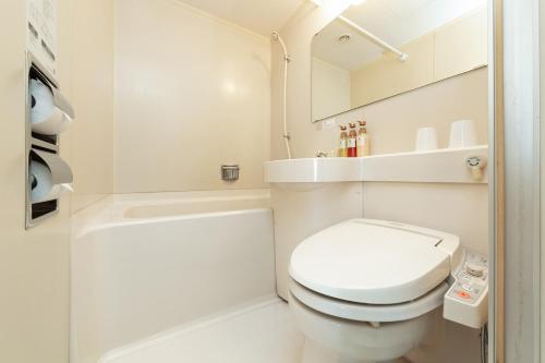 a small bathroom with a toilet and a shower at Plaza Hotel Tenjin in Fukuoka