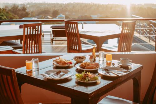 ein Tisch mit Tellern voller Essen auf einem Balkon in der Unterkunft The View Rawada Phuket in Rawai Beach