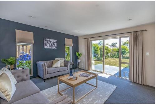 a living room with a couch and a table at Airport, motorway, shopping handy in Christchurch